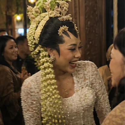 Dinda tertawa saat berbalik menyapa tamu resepsi