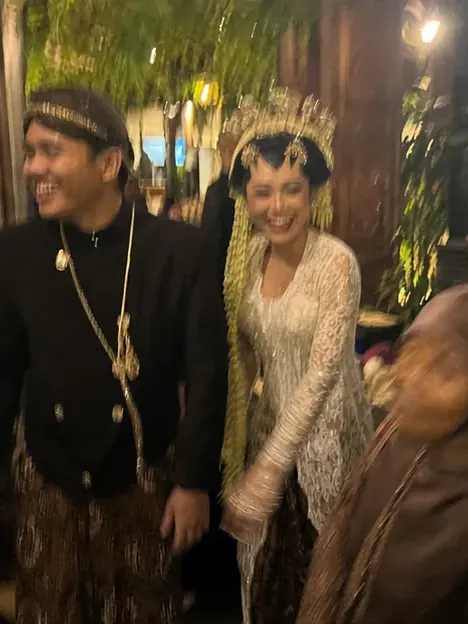Dinda dan Rafi berjalan sambil tertawa bersama tamu
